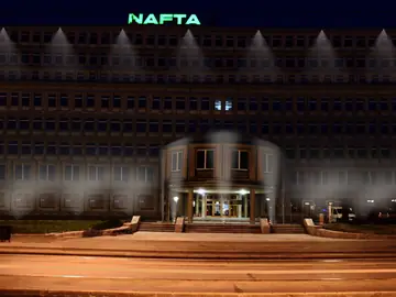 Podświetlona nocą fasada budynku z napisem NAFTA
