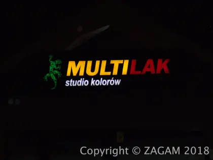 Świecące litery MULTILAK studio kolorów na ciemnej fasadzie